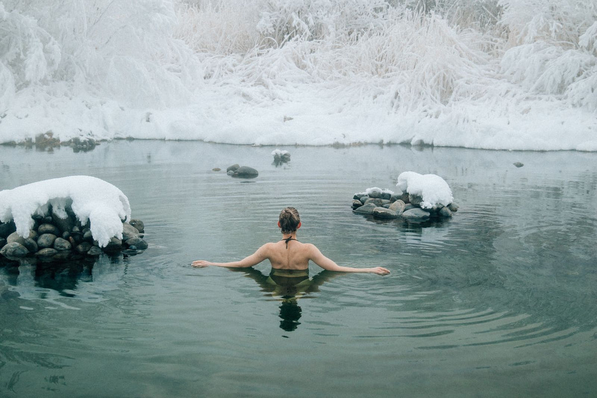 A person swimming in a tranquil cold lake