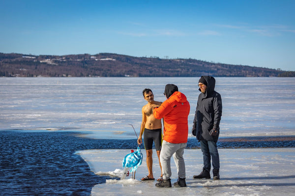 People cold-water swimming together at a sunny frozen lake