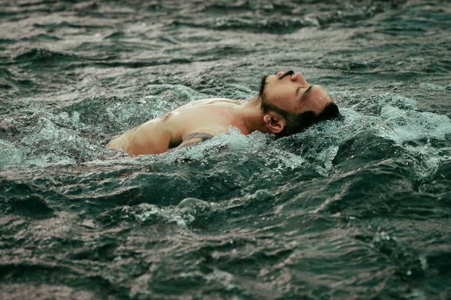 A person floating calmly in open water with eyes closed