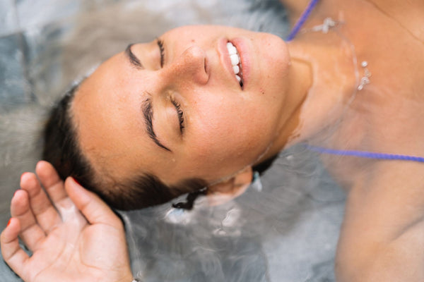 A person floating calmly in water with eyes closed, relaxed